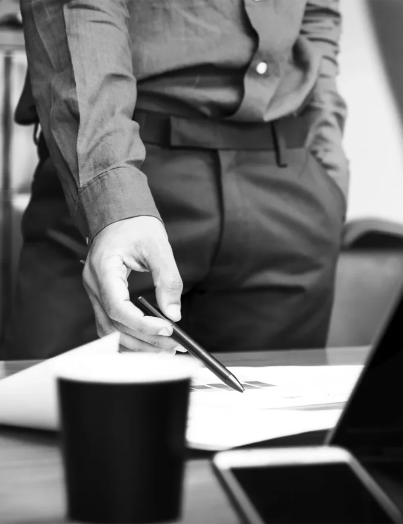 Image of a man pointing to a paper on a desk
